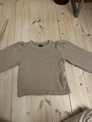 Grå stickad tröja Gina Tricot XXS💕💕💕 - Supersöt beige stickad tröja från Gina Tricot i storlek XXS. Tröjan har unika puffiga långarma💖💖💖