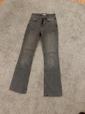 Grå bootcut mid waist jeans - Snygga grå jeans med bootcut passform och klassisk femficksdesign. Säljer pga för små 