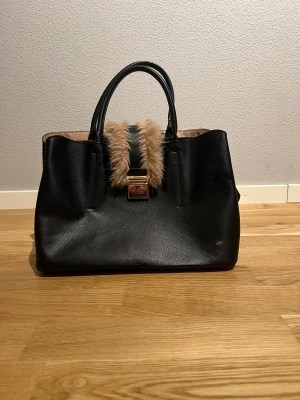 Handväska - Svart Handväska för kvinnor. Väskan är i nyskick, inga skador/brister. Köpt från H&M. Hör av vid intresse/frågor. PRIS KAN DISKUTERAS!