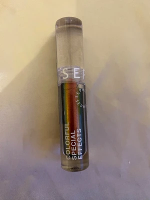 Sephora Colorful Special Effects ögonskugga - Multikrom flytande ögonskugga från Sephora i färgen 04 Galactic Red. Ger en cool regnbågseffekt med skiftande nyanser av rött, blått, grönt och guld. Kommer i en genomskinlig tub med applikator för enkel applicering.