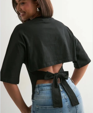 Svart topp med rosett  - snygg topp från Nelly!! säljer för den inte har kommit till användning 