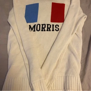 Vit stickad tröja Morris, M - Vit stickad tröja från Morris med ribbade muddar och rund hals. Framsidan har Frankrikes flagga. Priset är ej hugget i sten!!!