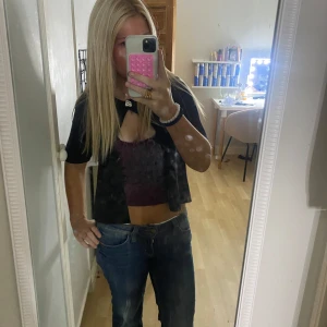 Svart kortärmad topp från Gina Tricot - Svart, stilren topp från Gina Tricot med rund halsringning och korta ärmar. Modellen är croppad och har en enkel, clean look som passar till jeans eller kjol. Materialet känns mjukt och lite tjockare, perfekt för en trendig vardagsoutfit.