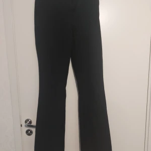 Svarta bootcut byxor från BikBok - Svarta bootcut byxor från BikBok i storlek 36. Byxorna har en klassisk passform med utsvängda ben och stängs med dragkedja och knapp. Perfekta för en stilren och trendig look.