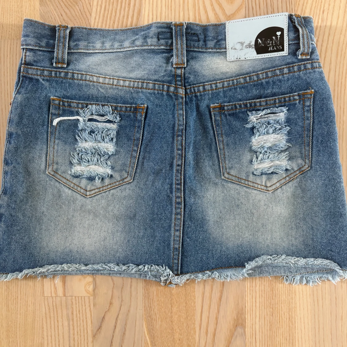 Blå jeanskjol med slitna detaljer - 1