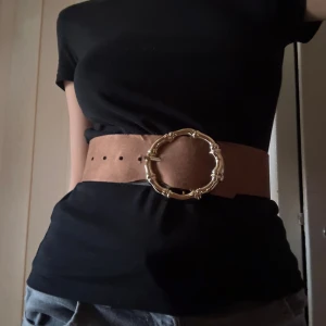 Bred brunt bälte med guldspänne  - Snyggt och brett bälte från H&M. Passar jättebra på vita klänningar.