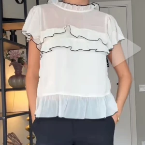 Aldrig använd vit blus med volanger och svarta kanter - *lånade bilder*Supersöt vit/ljusbeige blus med volanger och svarta kanter. Storlek 38 men passar mig som vanligtvis är en s. Aldrig använd med prislappen kvar, nypris 350