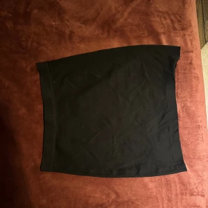 Svart kortkjol från Calvin Klein Jeans - Svart, stilren kortkjol från Calvin Klein Jeans med elastisk midja där loggan är diskret invävd. Kjolen har en rak och tight passform, tillverkad i mjuk material som känns skön mot huden. Perfekt för dig som gillar en clean look. Köparen står för frakten