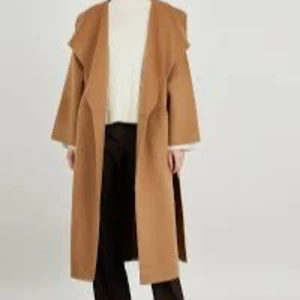 Totême Kappa 100% Wool Cashmere Camel - Säljer helt ny Totême Kappa Signature Wool Cashmere Camelen, ordinarie pris 15000 kr ,snygg och stilren lång kappa i beige med bred krage och öppen front. Jackan har en loose passform och är perfekt för dig som gillar en avslappnad men trendig look. Passar till både jeans och kostymbyxor. 