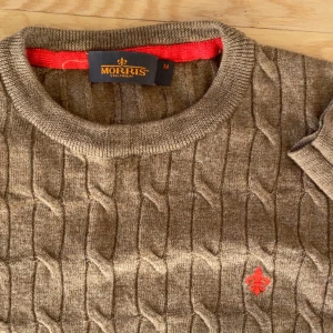 Beige kabelstickad tröja från Morris - Riktigt fin tröja från Morris i 100% merinoull🥰. Riktigt mjuk och skön. Lappen i nacken är dels av men inget som påverkar helhetssynen, annars helt felfri. 