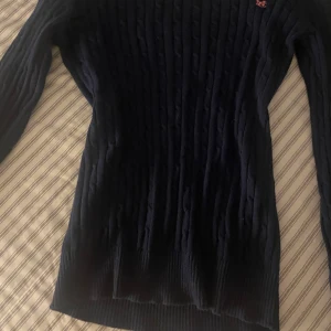 Stickad tröja  - Mörkblå stickad tröja med rosa detalj. 