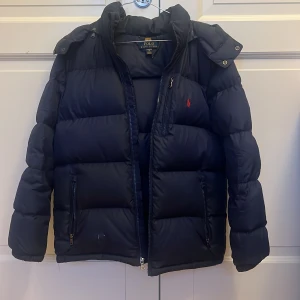 Polo Ralph Lauren jacka - Polo Ralph Lauren jacka i storlek xl (barn 18-20) och sitter ungefär som en xs. Jackan är i skicka 7/10 har rivits upp lite vid högra fickan. Använt i 1 år.