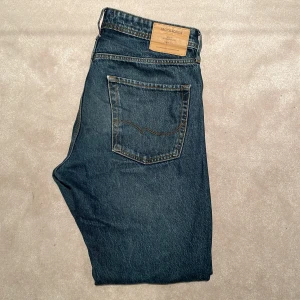 Mörkblå jeans - Snygga mörkblå jeans från Jack and Jones i storlek 32/34. Modellen är chris