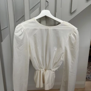 Vit blus med långa ärmar - Nu säljer jag min jättefina vita blus då den inte kommer till användning. Säljes för 100kr. Pågrund av smink fläcken vid halsen är därför priset lågt. Postar fort efter köp. 