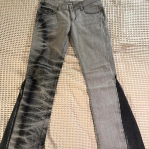 Grå bootcut jeans med svarta detaljer - Jättecoola jeans som är färgade och sydda till bootcut. Köptes på Vinted men var tyvärr för stora på mig. De är i storlek 40 men sitter som en  M/L. Midjemått: Ca 40 cm och Innerbenslängd: ca 82cm💞