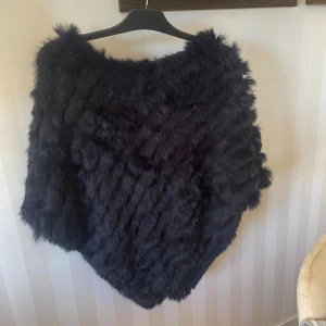 Svart poncho  - Svart poncho i äkta päls. One size