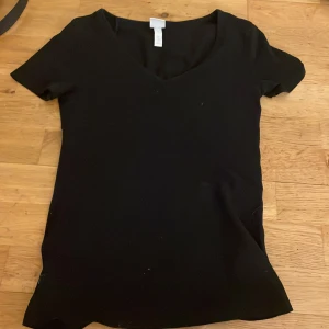 Svart v-ringad topp från H&M - I storlek XS