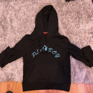 Supreme x Playboy svart hoodie S - Svart Supreme x Playboy hoodie med blått tryck på bröstet och broderad Supreme-logga på ärmen. Klassisk känguruficka, huva med snörning och mjukt material. Prima skick storlek S.Perfekt för dig som gillar streetwear och vill sticka ut med en ikonisk collab. Säljer för den e för liten för mig, är 178cm.