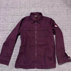 Äkta Manchester United jacka - Storlek 13-14 år men skulle även säga xs herr. Fin vinröd färg men knäppe vid ärmarna och dragkedja! Inga defekter. Kom med bud!!