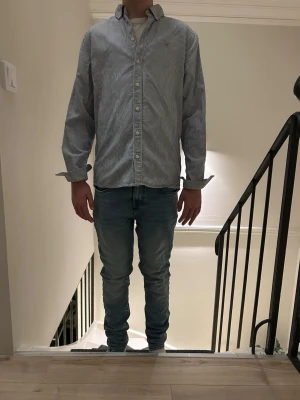 Skjorta från gant  - Snygg blåvit randig skjorta från gant med klassisk krage och knäppning framtill. Skjortan har lång ärm och en avslappnad passform, perfekt för en stilren look. Tillverkad i mjuk bomull som känns skön mot huden.