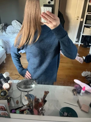 Mörkblå stickad tröja med rund hals - Mysig mörkblå stickad tröja med rund hals och ribbade muddar vid ärmslut och nederkant. Tröjan har en avslappnad passform och är perfekt för kyliga dagar. Passar till jeans eller kjol för en enkel och snygg look. pris kan diskuteras 