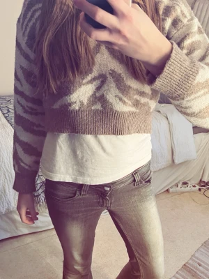 Beige zebramönstrad stickad tröja - Säljer en croppad stickad tröja i beige och vitt med zebramönster. Skitsnyggt med ett vit linne under 💕🦓
