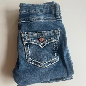 Blå jeans med kontrastsömmar - Snygga blå jeans med vita sömmar och snygg bakficka från Gina💗 strlk 164🩷. Har trampats upp vid halarna så små hål finns men inget man tänker på💗 Använda Max 3 ggr då dem blivit för små. Perfekta för dig som gillar en avslappnad men ändå stilren look.