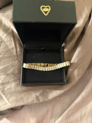 Guldigt armband med diamant kristaller - Snyggt armband i guldton med flera rader glittrande strass. Det finns en extra avtagbar länk för olika passform💞Armbandet har en klassisk, rektangulär länkdesign och stängs med ett smidigt spänne. Perfekt för dig som gillar att sticka ut med accessoarer som verkligen syns.