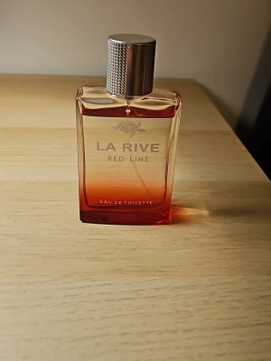 La Rive Red Line Eau de Toilette 90ml - La Rive Red Line Eau de Toilette (90ml) är en parfym i en snygg glasflaska med röd och transparent färgton. silverfärgat lock med struktur. Perfekt för dig som gillar fräscha och moderna dofter. Lite använd typ 4ml. Jag har skrivit Tim på flaskan som jag tyvär inte får bort😅. Säljer den för bra pris på grund av att jag inte använder den.