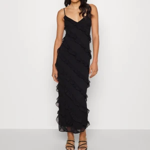 Volangklänning ginatricot  - Superfin svart långklänning från Ginatricot i storlek M men liten i storleken. i nyskick!