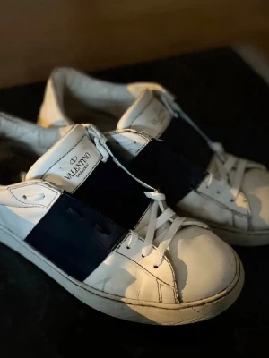 Valentino open - OBS: stort hål i sulan. Kolla bild 2 samt 6.                        Säljer ett par Valentino Open sneakers, storlek 41. Skorna är använda och har ett stort hål i sulan (se bilder). I övrigt är skon i okej skick.                                       Pris kan diskuteras. Skicka förslag!