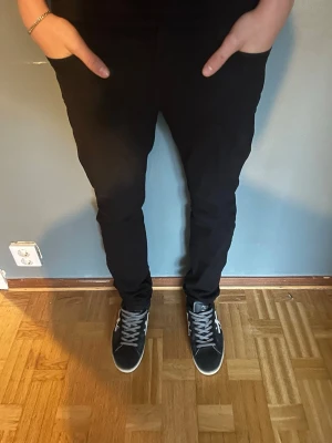 Svarta slim jeans från Moschino - Säljer ett par svarta Moschino jeans med slim passform. Klassisk femficksmodell och snygg moschino-plaque i guld där bak. Jeansen är i stretchigt bomullsmaterial och har en modern, smal siluett som passar till det mesta. Nypris: 6000