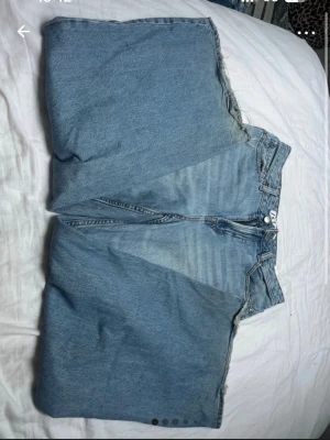 Baggy streetwear jeans - Säljer ett par ljusblå wide jeans med hög midja och raka ben. Klassisk femficksmodell i mjukt bomullsjeansmaterial. Perfekta för en avslappnad och trendig look.