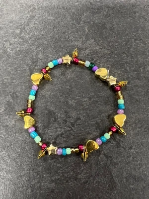 Färgglatt pärlarmband med berlocker Storlek XS  - färgglatt pärlarmband 