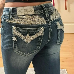 Miss Me jeans med broderade detaljer💕 - Säljer ett par blå Miss Me jeans med snygga broderade och glittriga detaljer på bakfickorna och linningen. Jeansen har låg midja.💕