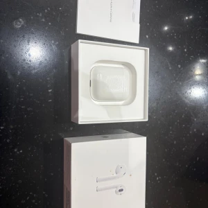 Apple AirPods (2nd Generation) med laddningsetui - Säljer ett par Apple AirPods (2nd Gen) med original laddningsetui och förpackning. Hörlurarna är i mycket bra skick och de fungerar felfritt. Hör av er vid frågor!!!