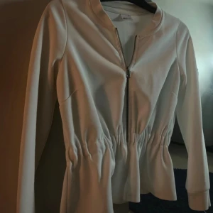 Vit tröja med dragkedja - Väldigt söt tröja i strl S med dragkedja, modellen är lite öppen nertill. Den har en liten fläck men syns knappast eftersom den är i samma färg som tyget. (Bild finns)☺️