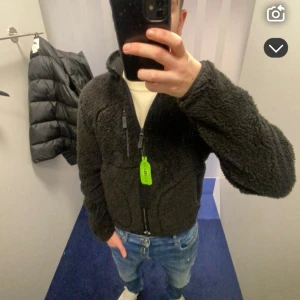 svart fleecejacka från j lindeberg - svart fleece jacka från j lindeberg med hel dragkedja framtill, hög krage och tre fickor med dragkedja. Jackan är fluffig och har en clean look som passar perfekt till kalla dagar. Snygg och enkel att matcha med jeans, skriv dm vid frågor! ny pris 2000 kr