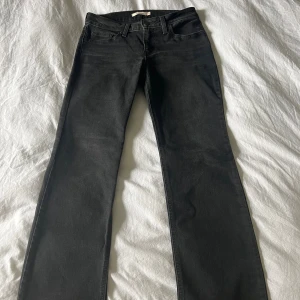 Lågmidjade Levi’s Jeans - Svarta lågmidjade raka jeans från Levi’s. Använda varsamt så ser nya ut. Storlek W28/L30. Nypris var 599 kr. 