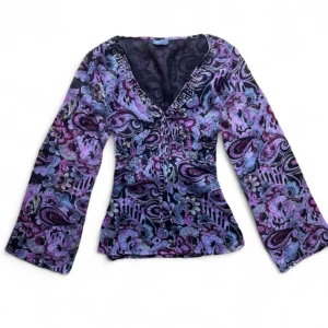 y2k vintage blommig lila blus från Perspective - Supersnygg blus med blommigt mönster i lila, rosa och svart från Perspective. V-ringad med snörning framtill och pärldetaljer längs halsringningen. Långa ärmar och figurnära passform, Knyts i ryggen. 