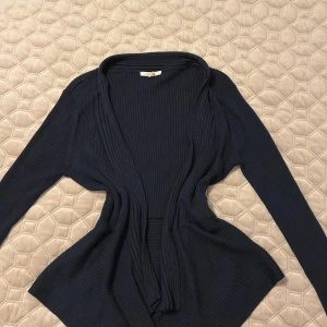 Mörkblå ribbad kofta från Esprit - Snygg mörkblå kofta från Esprit med ribbad struktur och långärmad design. Koftan är öppen framtill och har en mjuk, följsam passform som gör den enkel att slänga på över en t-shirt eller topp. Perfekt för dig som gillar stilrena och bekväma plagg. Helt oanvänd! (Trots att det står xxl passar den mig som har S i storlek så låt er inte skrämmas av det) Skulle säga den är one-size