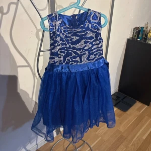 Blå barn klänning - Det passar till barn mellan 5-7år. Perfekt för dig som vill sticka ut med en cool och festlig look. 
