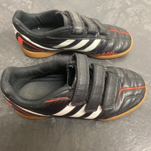 Adidas futsalskor (inomhus) - Size 34 EU - Säljer ett par Adidas futsalskor inomhusskor i mycket bra skick. Skorna är välvårdade med endast lätt slitage i form av små repor runt om skorna.  Ingenting som påverkar helhetsintrycket eller funktionen.  OBS! Originalkartong medföljer inte. 💸 Billigare pris vid köp av flera par skor!