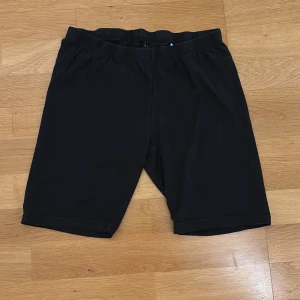 Cykelbyxor från Ellos - Svarta shorts från Ellos med elastisk midja och enkel, stilren design. Modellen är knälång och har en normal passform. Materialet känns mjukt och lätt, perfekt för varma dagar. Snygga att matcha med en t-shirt eller hoodie.
