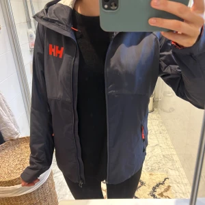 Helly Hansen jacka  - Helly Hansen regn och vindjacka i storlek M, osäker på om det är en dam eller herr men tror dam! Bra skick men några slitningar, se bilder. 