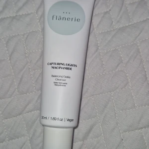 Cleanser  - Balancing Gelée Cleanser från Flânerie med niacinamide, kommer i en vit tub på 50 ml. Vegansk formula med ingredienser som vatten, glycerin och extrakt. Tuben har en minimalistisk design med ljusgrått tryck och skruvlock. Innehåller niacinamid, glycerin och vitamin E för att stödja hudens naturliga barriär.