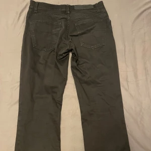 Svarta Tiger Of Sweden jeans - Säljer ett par svarta Tiger of sweden jeans med klassisk femficksdesign och raka ben. Byxorna har normal passform, bälteshällor och knappstängning fram. Materialet är slitstarkt jeans och färgen är helsvart, perfekt för en clean och stilren look.