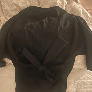 Nelly T-shirt med knytning bak  - T-shirt från Nelly i storlek xs som man knyter bak i ryggen 