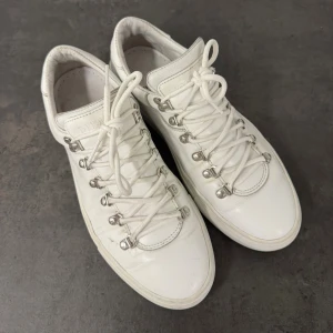 Diemme Marostica Low skor Vita - Säljer ett par vita sneakers från Diemme, tillverkade i Italien. Skorna har snörning med metallöglor och en platt sula. De är gjorda i mjukt skinn och har en rund tå. Perfekta för dig som gillar stilrena och klassiska sneakers med coola detaljer.