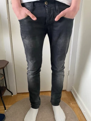 Replay Anbass Jeans - Säljer ett par svarta slim fit jeans med lätt tvättade detaljer och klassisk femficksmodell. Jeansen har smal passform och normal midja, perfekta för en trendig och avslappnad stil. De är bra skick | Nypris ~ 1299 | Säljer för 349 |